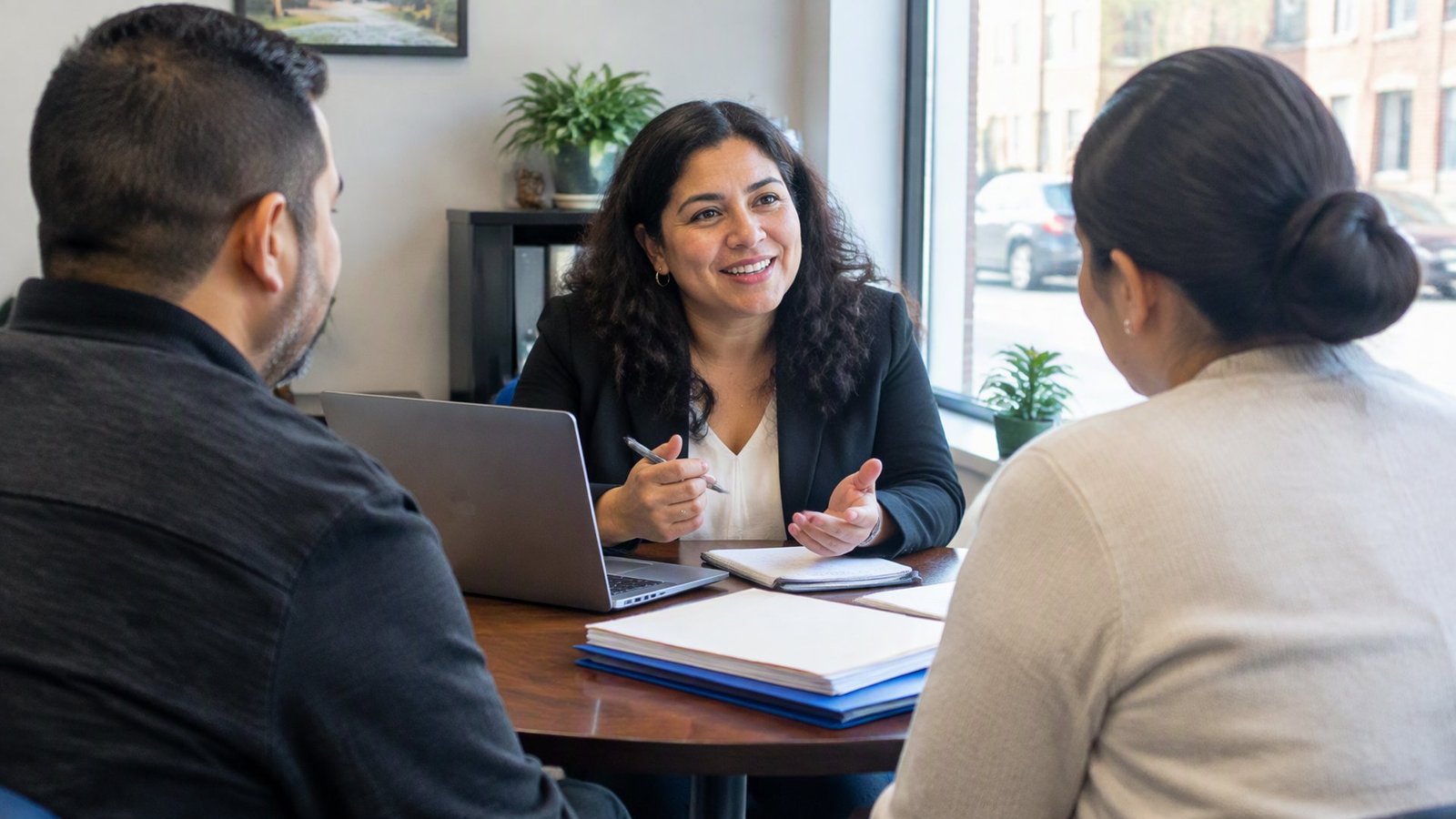 A bookkeeping business founder meeting with clients at a small table in her street-level office