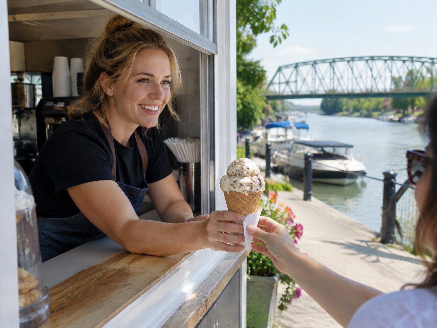 A Tonawanda ice cream stand owner handing a cone to a customer beside the Erie Canal waterfront
